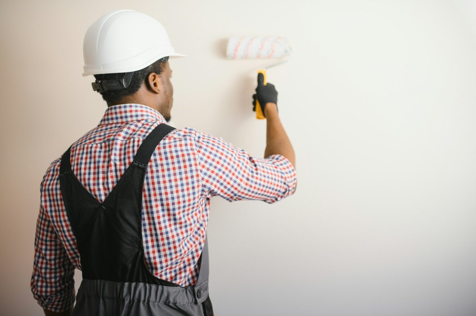 African-American painter doing repair in room